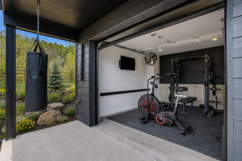 Home gym garage with pull-up rig, weight bench, and punching bag